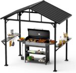 The gazebo set up outdoors with hardtop roof and side table for grilling.